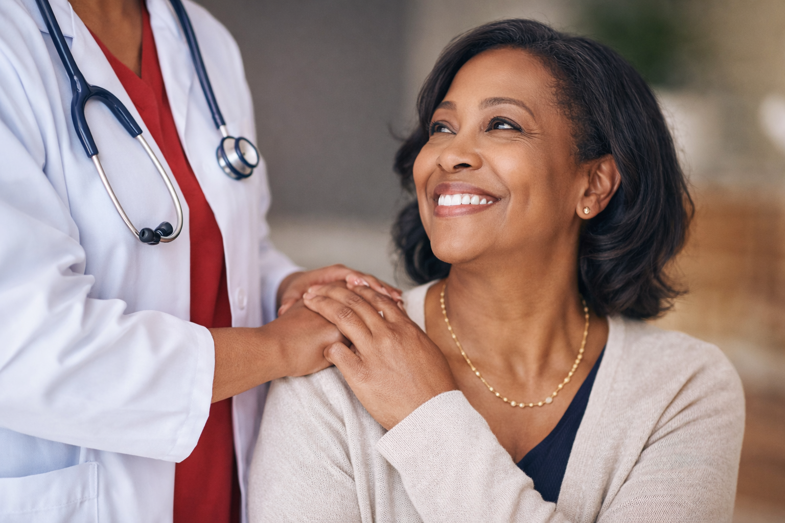 Smiling female patient looking up at her healthcare provider during a supportive medical visit at a clinic.